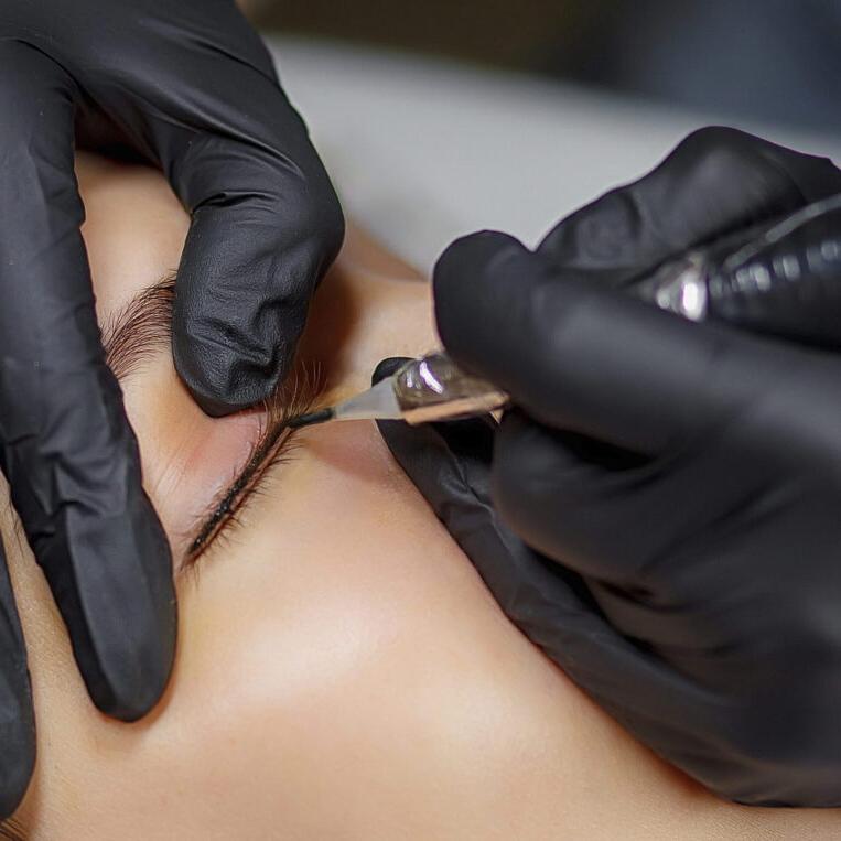 eyeliner tattooing being performed